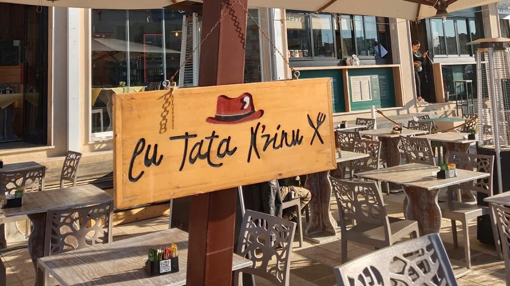 Insegna in legno di Lu Tata N'zinu sul dehors di Piazzetta Idro a Otranto